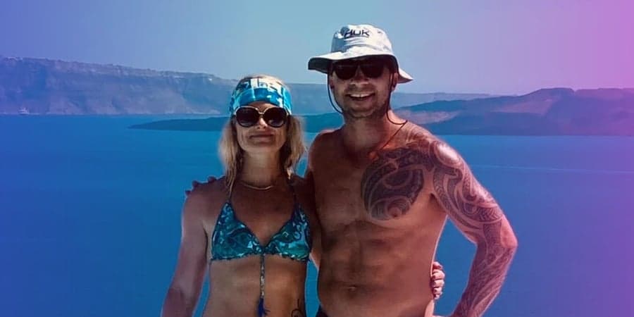 Jeremy Beland and his partner posing in front of a large body of water