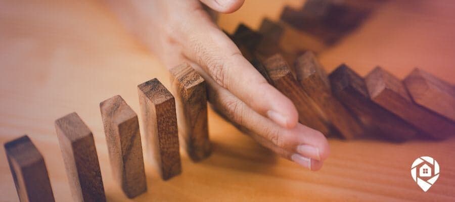 Dominoes being stopped from knocked over symbolizing Contingency in Real Estate