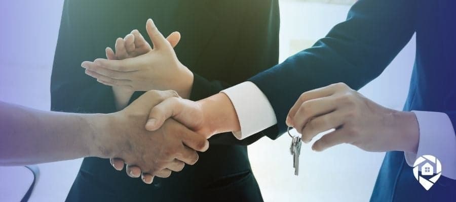 Real estate wholesaling deal closed with handshake and keys exchange.