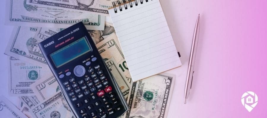 Pile of money with a calculator and notebook to calculate using retirement funds to buy an investment property.