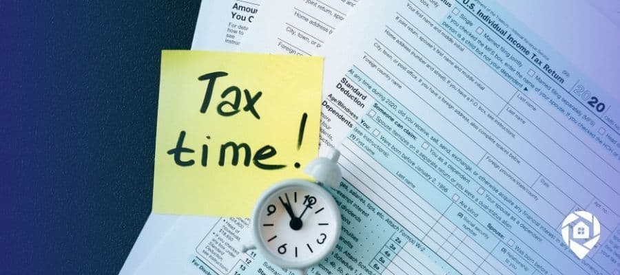 ax documents and clock with sticky note saying 'Tax time' – real estate investor tax planning concept.