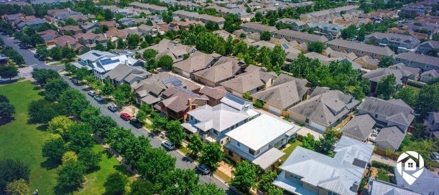 Aerial view of suburban houses - Discover Adam Levvingon's real estate investment strategies and why real estate is a good investment.