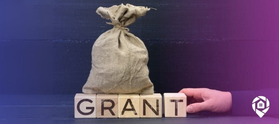 A bag of money with blocks that spell out grants, showing the money you can get by searching for grants for real estate investors.