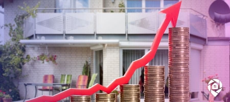 Stacks of money in front of a house background with an arrow increasing to show using a ROTH IRA to buy a house.