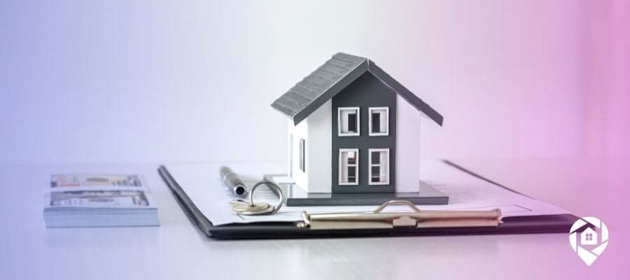 A house on top of a clipboard full of papers that are a guide for those looking to invest in properties.