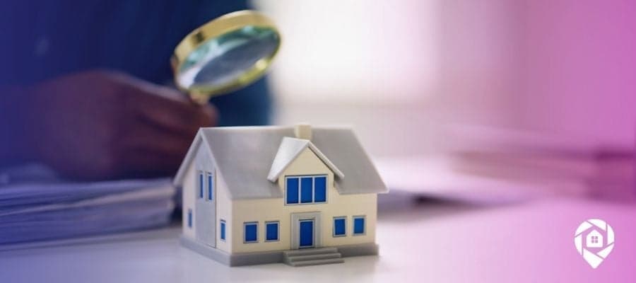 A magnifying glass over a house onto a table to symbolize looking into sub 2 real estate versus traditional bank loans.