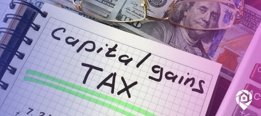 Money, glasses and a paper with capital gains tax written on it underlined.