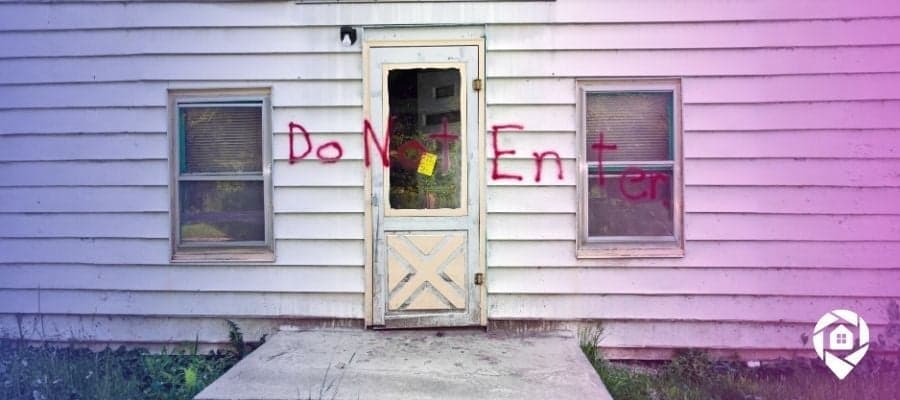 Condemned property with "Do Not Enter" spray painted on the vinyl siding.