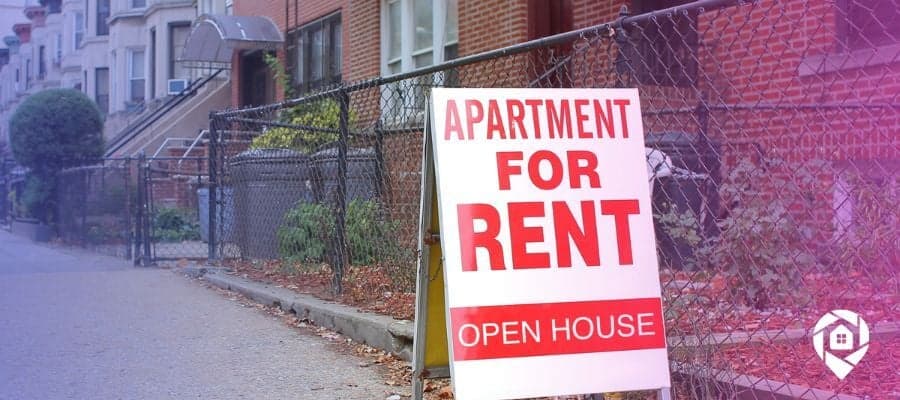 Apartment for rent sign in front of a row of available units