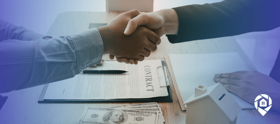 Two real estate investors shaking hands over a contract and cash deal, closing a property sale without marketing.