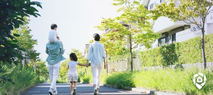 Family walking in a residential neighborhood near modern real estate homes.