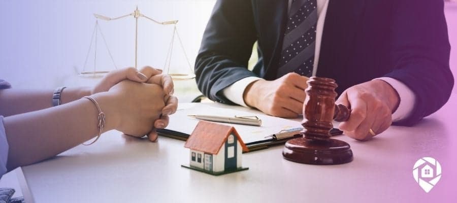 House and a gavel on a table with people in the background for finding preforeclosures near me.