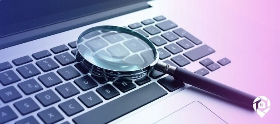 A magnifying glass on a computer keyboard symbolizing how to find accurate information on properties.