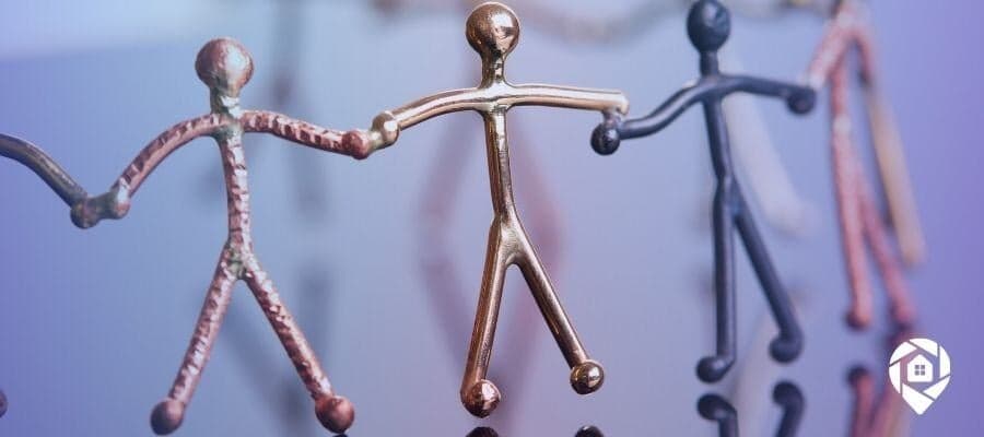 Metal stick figures holding hands, symbolizing teamwork and strong real estate investing connections.