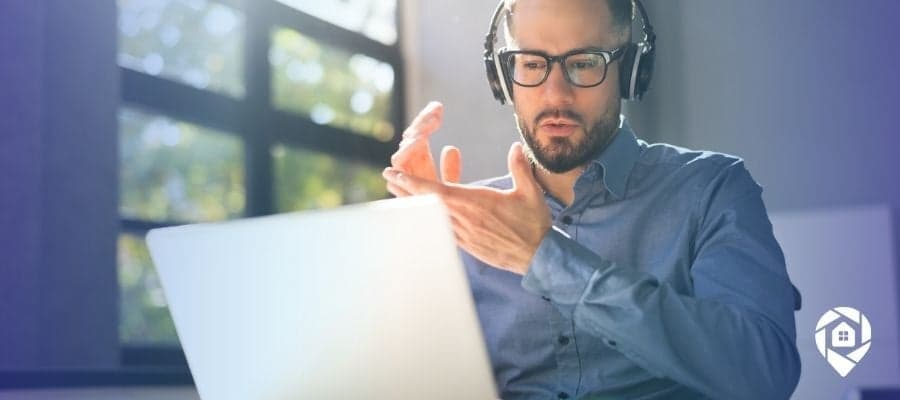 Man doing virtual real estate deal on laptop with headphones.