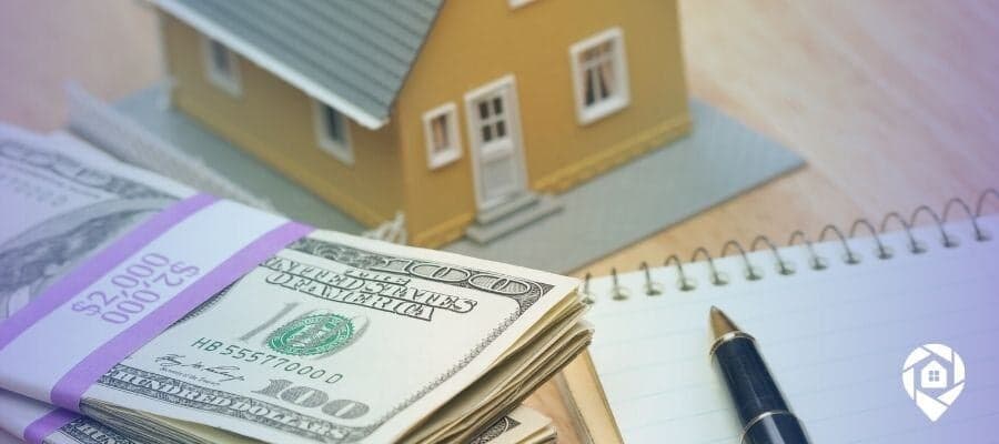 Cash and model house illustrating real estate financing strategies and rental property investing.