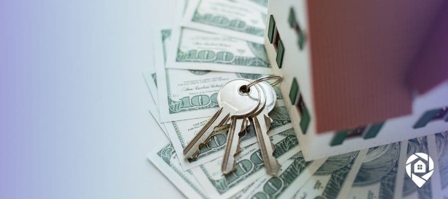 House keys on cash representing real estate wholesaling profits.