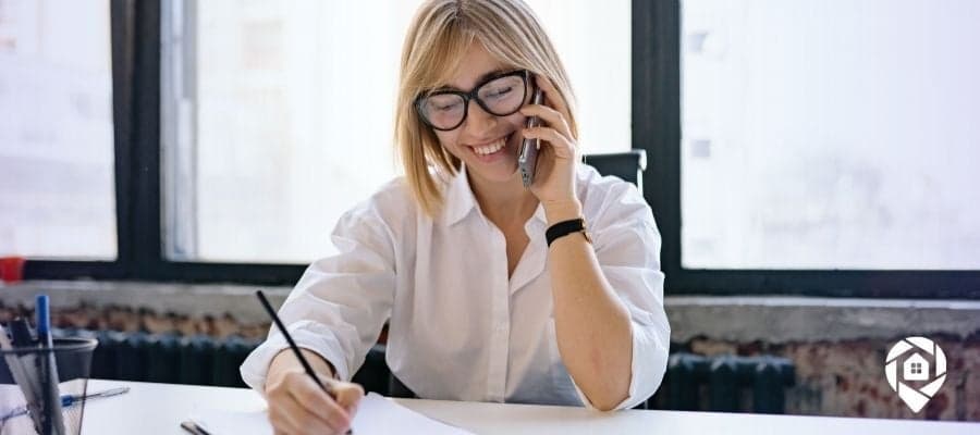 Smiling real estate agent cold calling motivated home seller to generate leads.