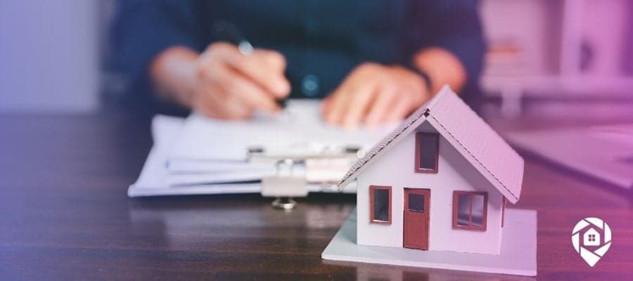 Representation of a property with delinquent taxes on a desk with someone writing notes.