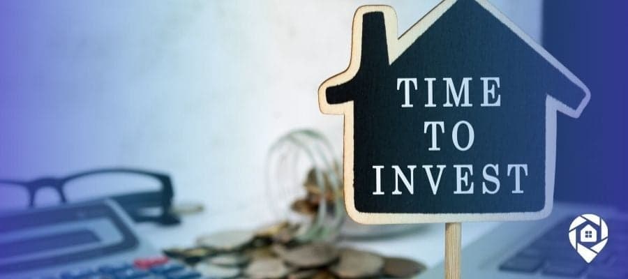 Time to invest in real estate sign with coins and calculator – start flipping, renting, or wholesaling properties for financial freedom.