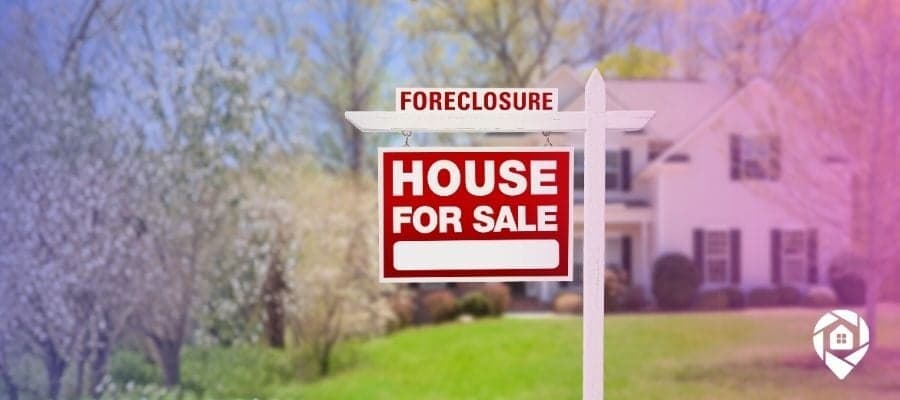 A for sale sign outside of a tax foreclosure home for sale.