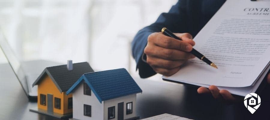 Real estate contract signing with miniature house models – Essential tools for landlords and property managers.
