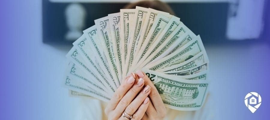 Real estate investor holding cash symbolizing passive income and financial freedom system.