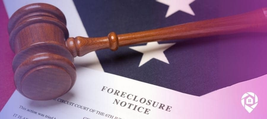 A gavel over a foreclosure notice on top of a US flag.