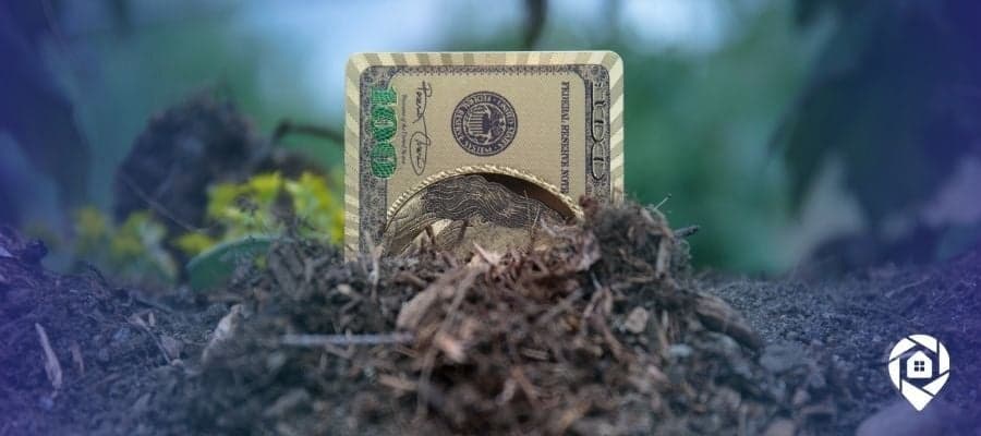 Hundred dollar bill buried in soil symbolizing land investing profits.