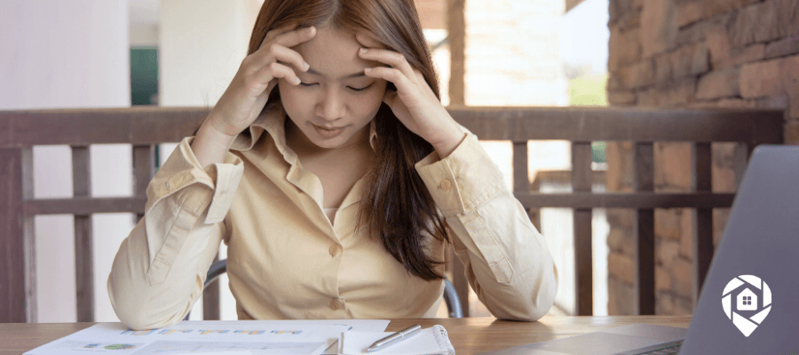 Stressed real estate investor reviewing failed property deal paperwork.