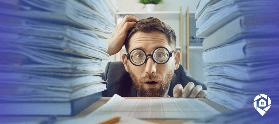 Overwhelmed real estate investor buried in paperwork, showing why a transaction coordinator helps deals close.
